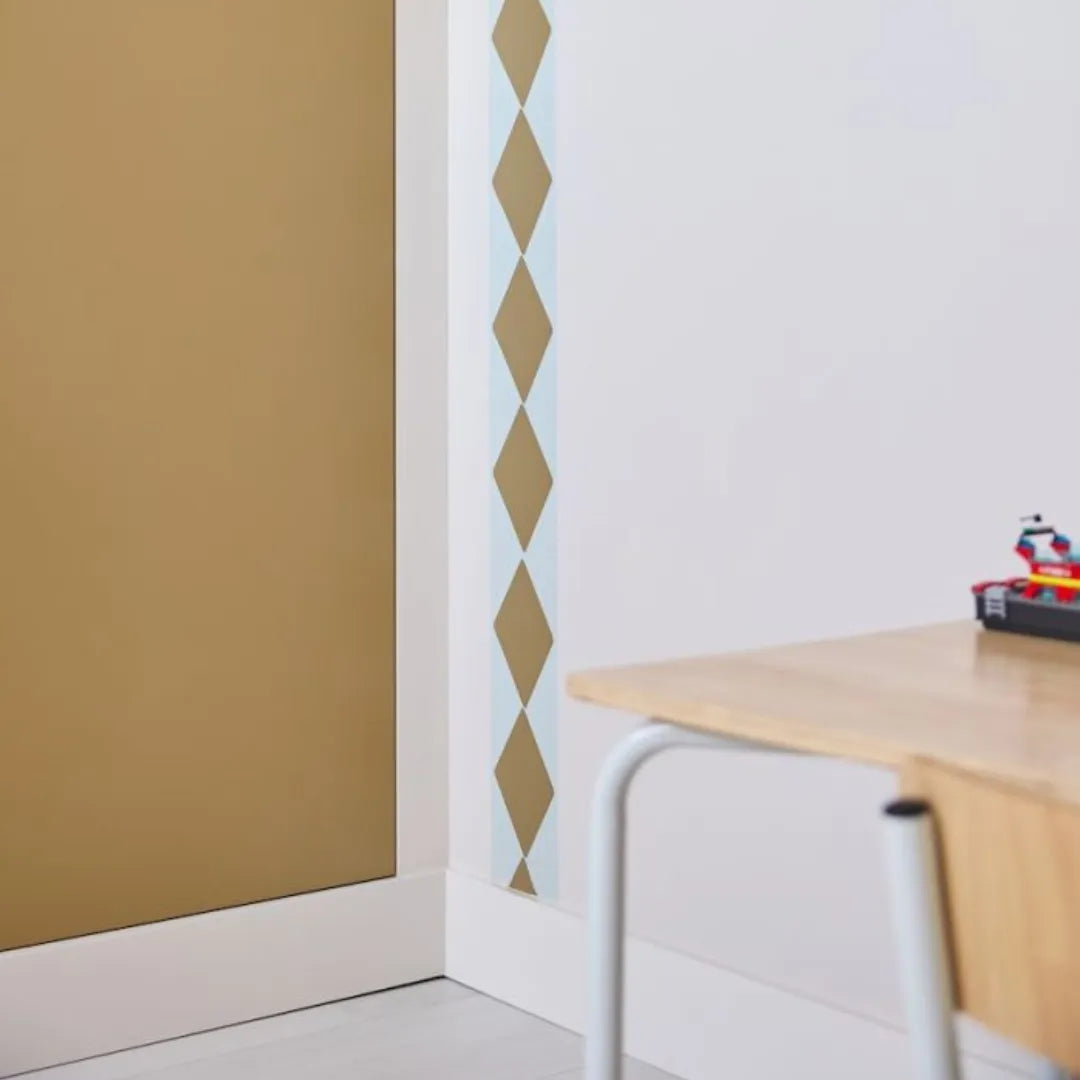 Hoek van een kinderkamer met de okerkleurige ruitenrand Wieber van Bibelotte verticaal naast een bureau
