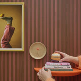 Gestreept cacao behang van Bibelotte achter een wandtafel met decoratie