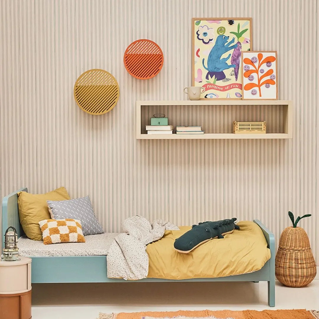 Bibelotte gestreept behang in een jongenskamer met blauw bed, geel dekbed en een wandplank